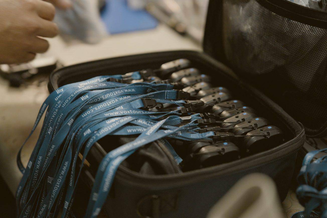 An open equipment case packed with blue Vox receivers and earphones
