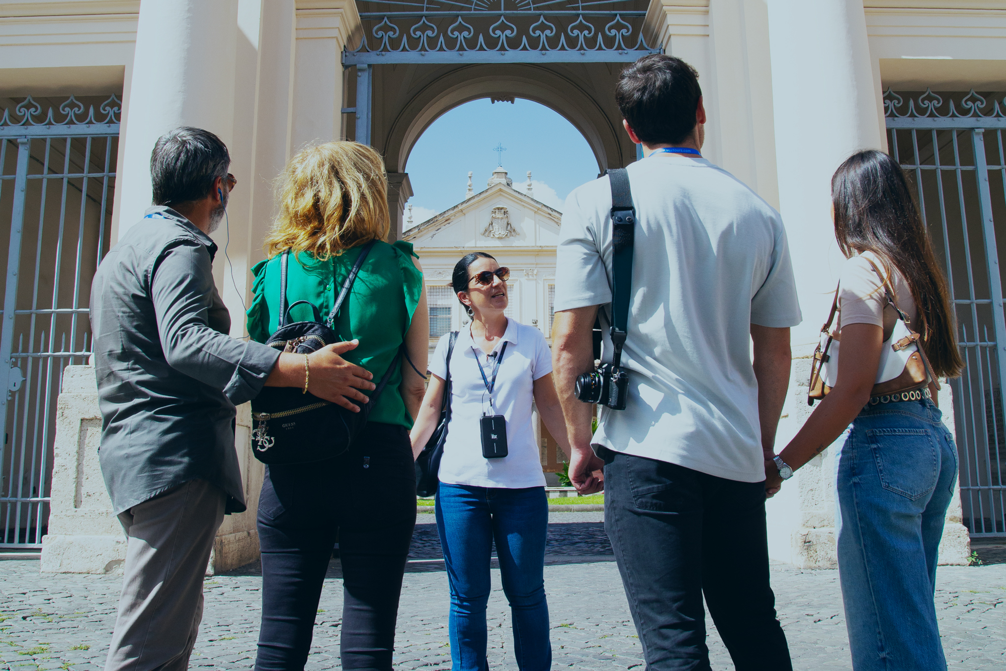Group with people coming from different countries listening a guide that in realtima is comment in their own language thanks to the Vox Aura device, the AI-powered multilingual live translation device.